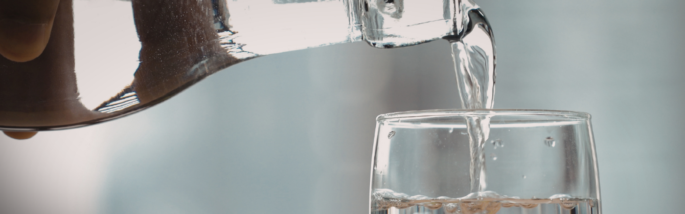 filling glass with pitcher of water