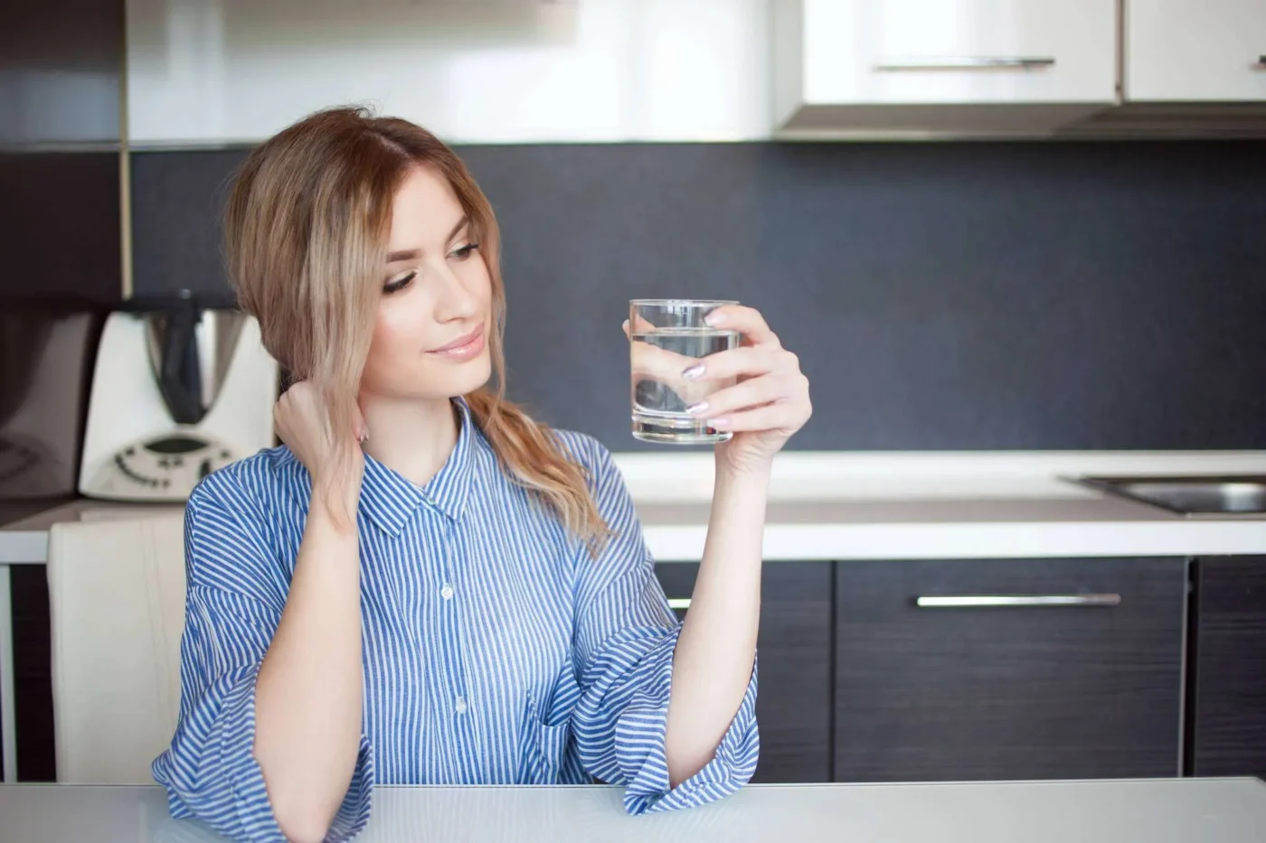 woman looking at a glass of water