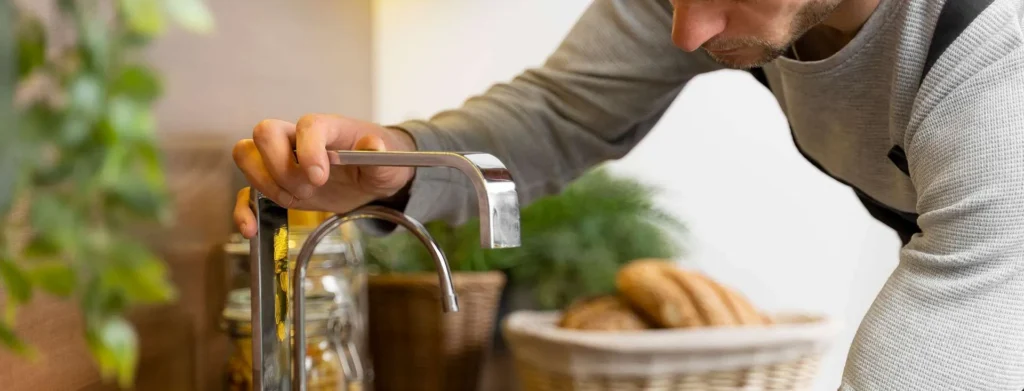 man inspecting water faucet