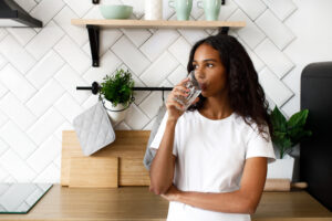 Hero-Image-Standing-in-kitchen-drinking-water-scaled